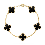 Gold bracelet with black clover-shaped charms on a white background