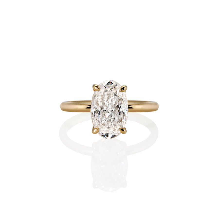 Top view of Bloom solitaire ring with an oval-cut moissanite set in a four-prong setting on a slim yellow band