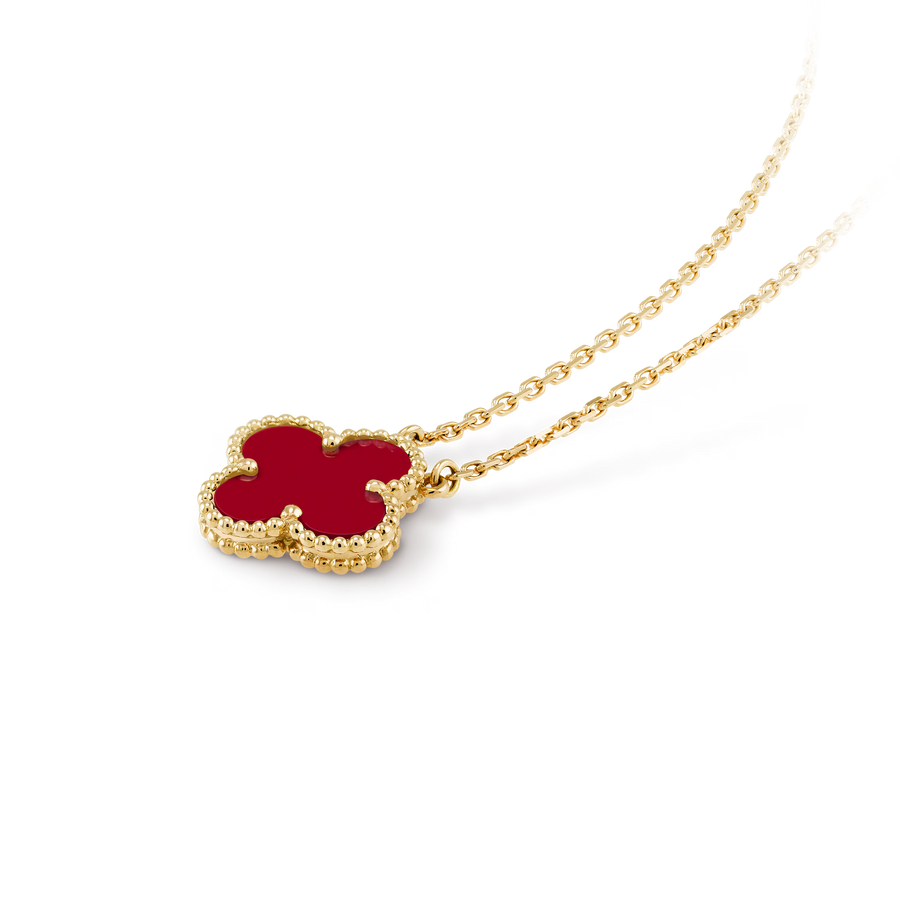 Gold necklace with a red clover-shaped pendant on a black background