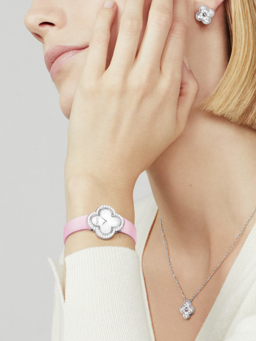 Close-up of a woman wearing silver jewelry with pink accents on a neutral background