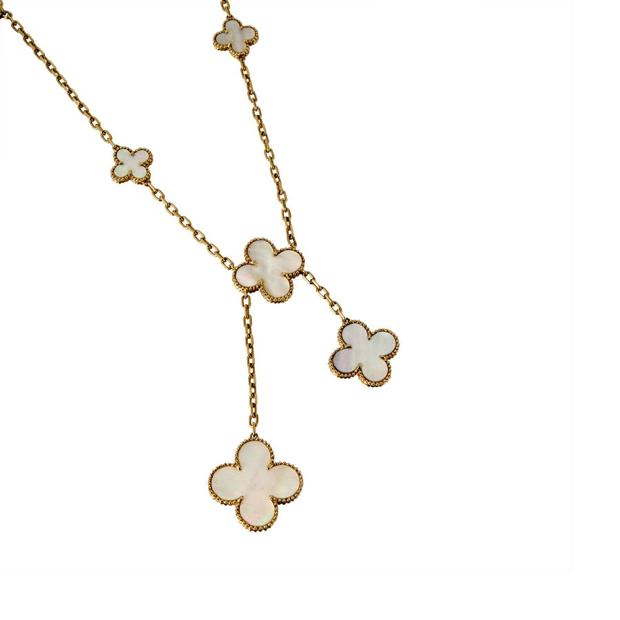 Detail shot of Clover Drop necklace with white shell clover charms on a gold chain