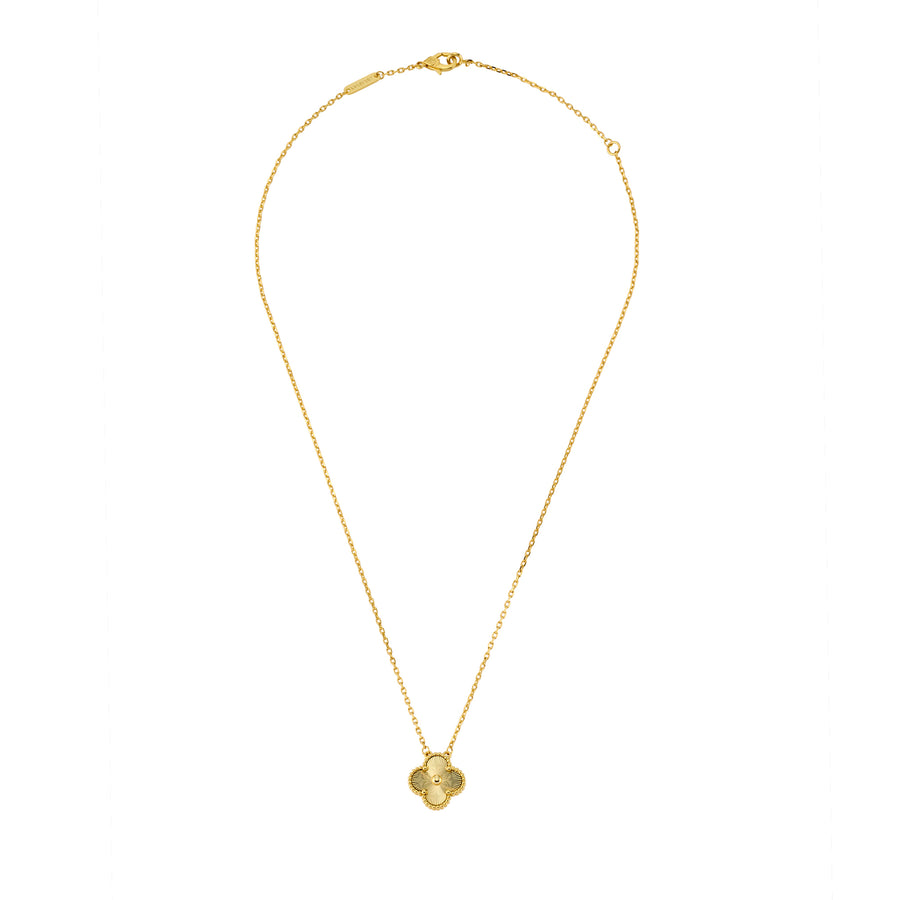 Full view of gold necklace with engraved clover-shaped pendant and beaded edge