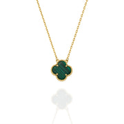 Close-up of gold necklace featuring clover-shaped malachite pendant with beaded trim