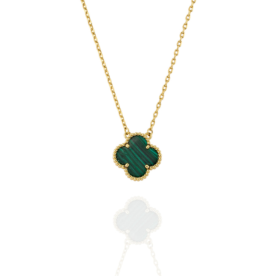 Close-up of gold necklace featuring clover-shaped malachite pendant with beaded trim