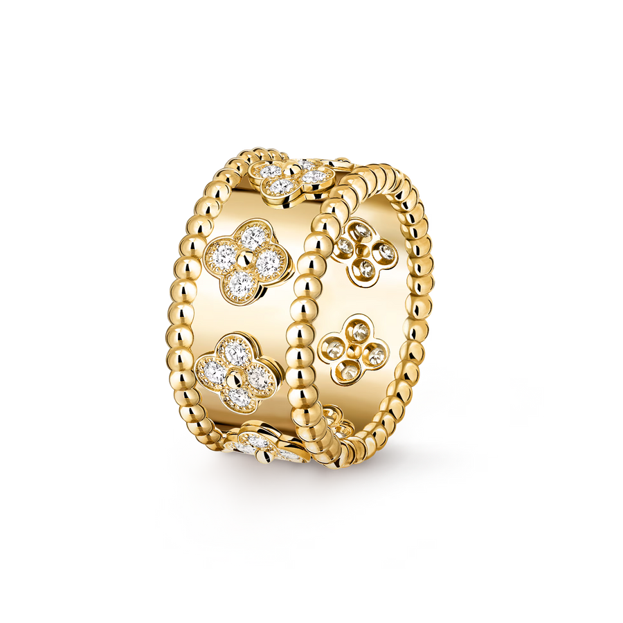 Gold ring with floral designs and clear stones on a white background