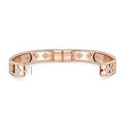Rose gold bracelet with intricate designs on a white background