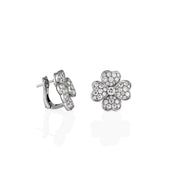 A pair of large heart-flower stud earrings crafted from white gold and pavé-set moissanite, shown at an angle.