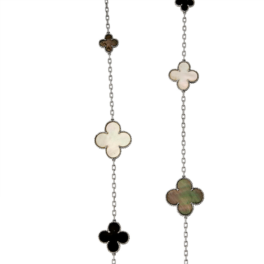 Close-up of Long Clover necklace showing beaded clover charms in black, white, and green inlay with silver chain links