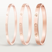 Three rose gold bangles on a light gray background