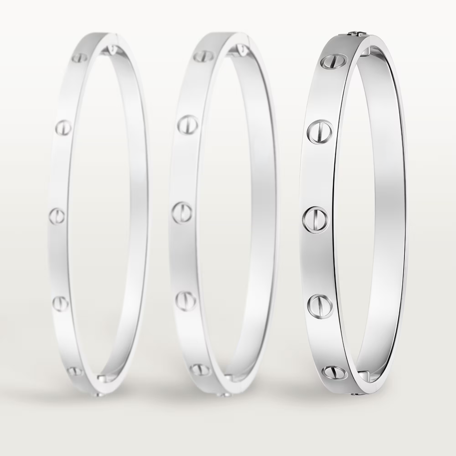 Three silver bracelets with circular patterns on a light gray background