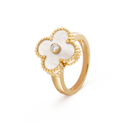 Gold ring with a white flower-shaped design and central gemstone on a transparent background