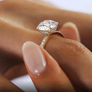 Holding the Aurora moissanite engagement ring between fingers