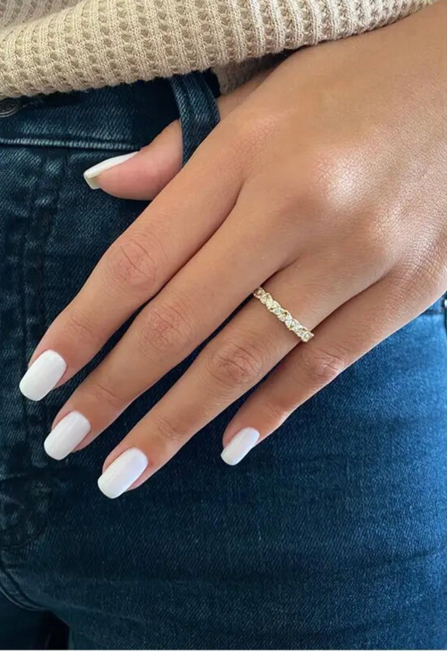 Close-up of marquise and solitaire moissanite band on finger