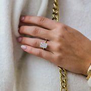 Faith ring with 5.5ct emerald cut moissanite worn on hand with gold chain