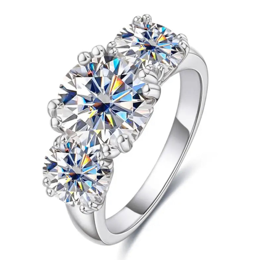 A trio of white moissanite stones set in a silver ring with a classic four claw setting.