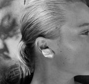 Close-up image of a person wearing a baroque pearl earring with a solid 925 sterling silver bar.