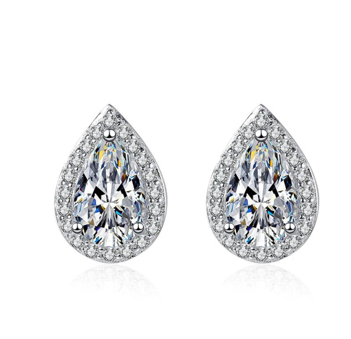 A pair of white color moissanite earrings with a pear cut design, set in silver.