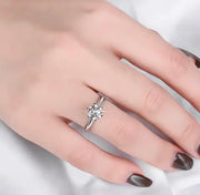 A woman's hand displaying a 1ct round solitaire Moissanite ring on her finger.