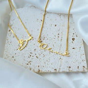 Two gold-colored necklaces with the names 'Soho' and 'Ocean' engraved on them, displayed against a white background.