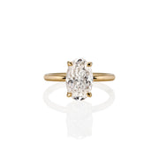 Top view of Bloom solitaire ring with an oval-cut moissanite set in a four-prong setting on a slim yellow band