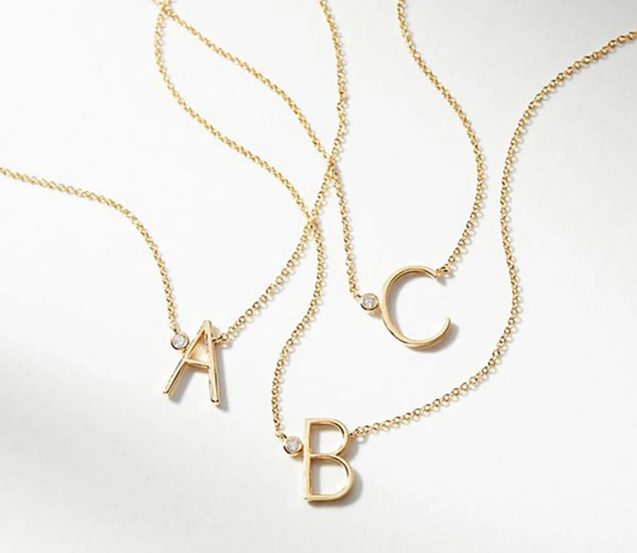 A gold vermeil necklace with large letters 'A', 'B', and 'C' on sterling silver chains.
