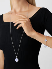 Woman wearing a black top with a necklace and bracelet on a white background