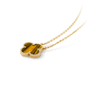 Gold necklace with a green gemstone pendant on a black background