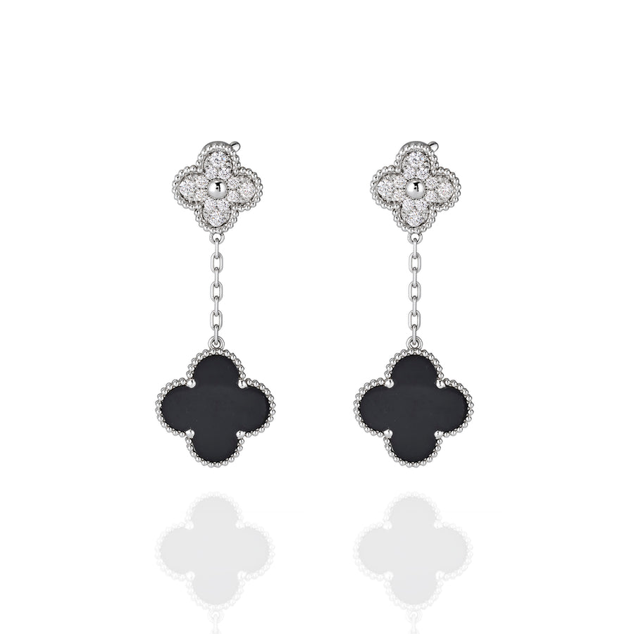 Front view of drop earrings with moissanite floral studs and black onyx clover pendants