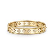 Gold bracelet with floral designs on a black background