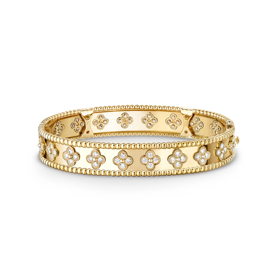 Gold bracelet with floral designs on a black background