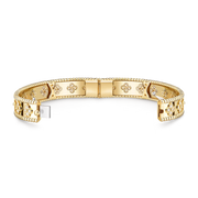 Gold bracelet with intricate designs on a white background