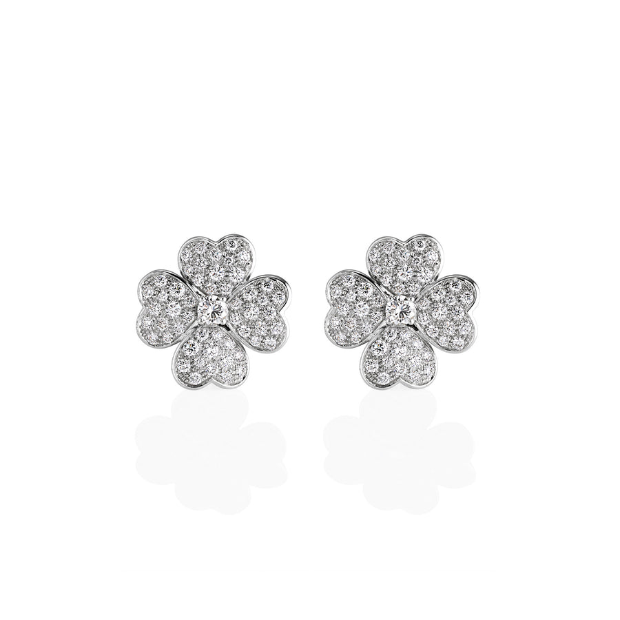A front view of large heart-flower earrings with sparkling pavé moissanite stones in a symmetrical floral pattern.