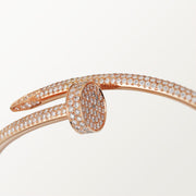 Rose gold bracelet with diamond accents on a light background