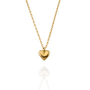 Close-up of a gold heart pendant on a fine chain, showing the brushed texture and soft curves of the charm.