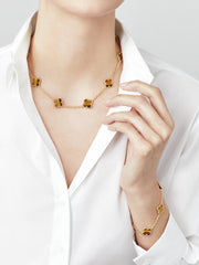 Gold necklace and bracelet on a person wearing a white shirt