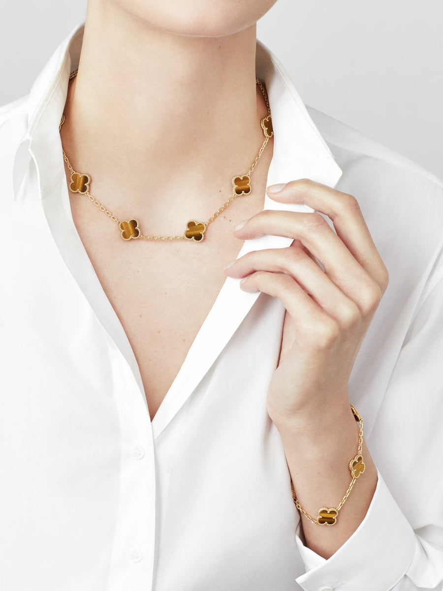 Gold necklace and bracelet on a person wearing a white shirt