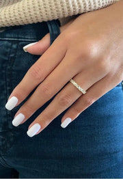 Close-up of marquise and solitaire moissanite band on finger