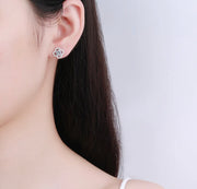 Clover studs worn on model ear – delicate and sparkly