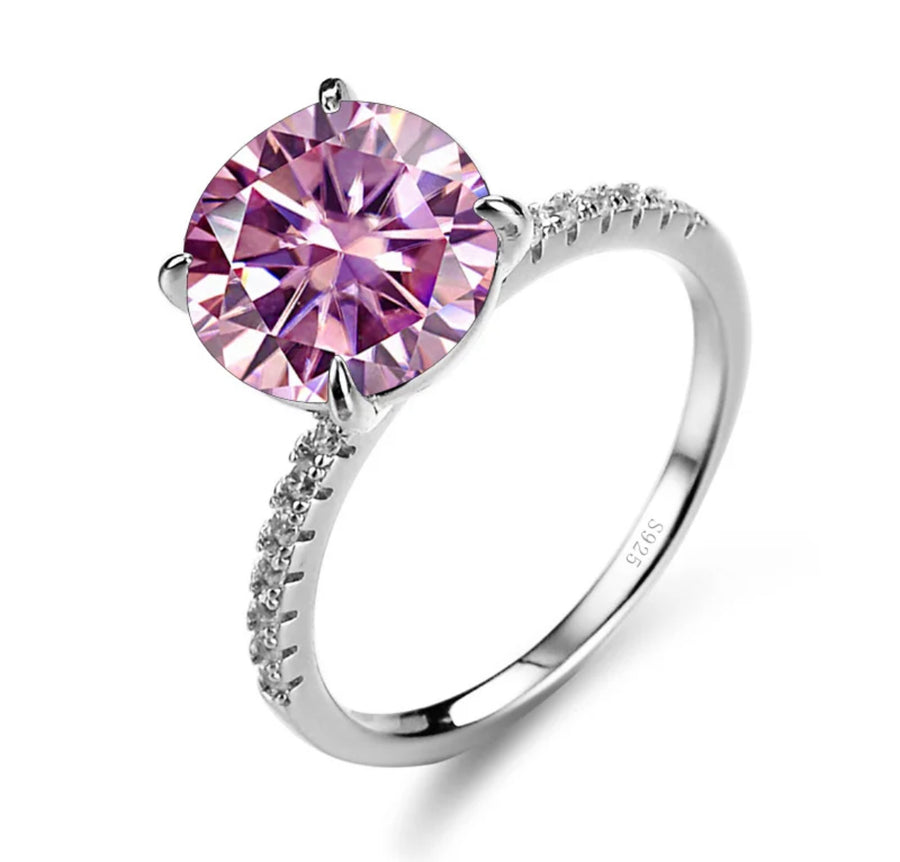 A silver ring featuring a pink Moissanite gemstone, set in a classic four-clawed setting.