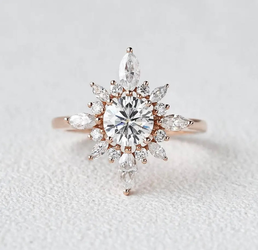 A round halo Moissanite ring with a solid 14k rose gold band, highlighting a central diamond surrounded by smaller clear stones.