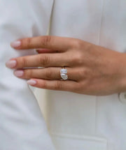 A hand displaying a double 4ct white Moissanite ring with white gold plating on a silver finger.