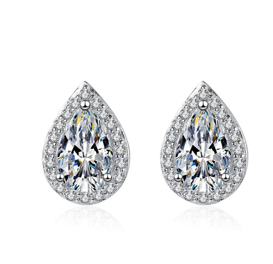 A pair of white color moissanite earrings with a pear cut design, set in silver.