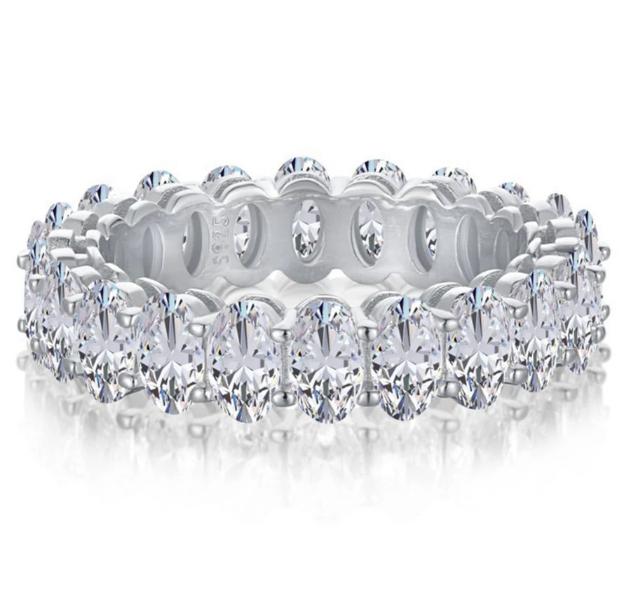 An oval-shaped moissanite band with silver and gold plating, featuring multiple gemstones.