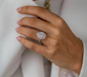 Portia ring worn on hand holding sleeve, sparkling in natural light