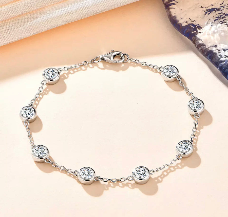 Rhianna Moissanite bracelet shown laid flat on soft pink background.